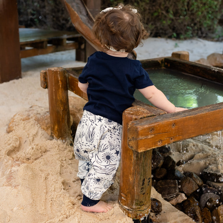 Child playing in a sand pit with wooden structures