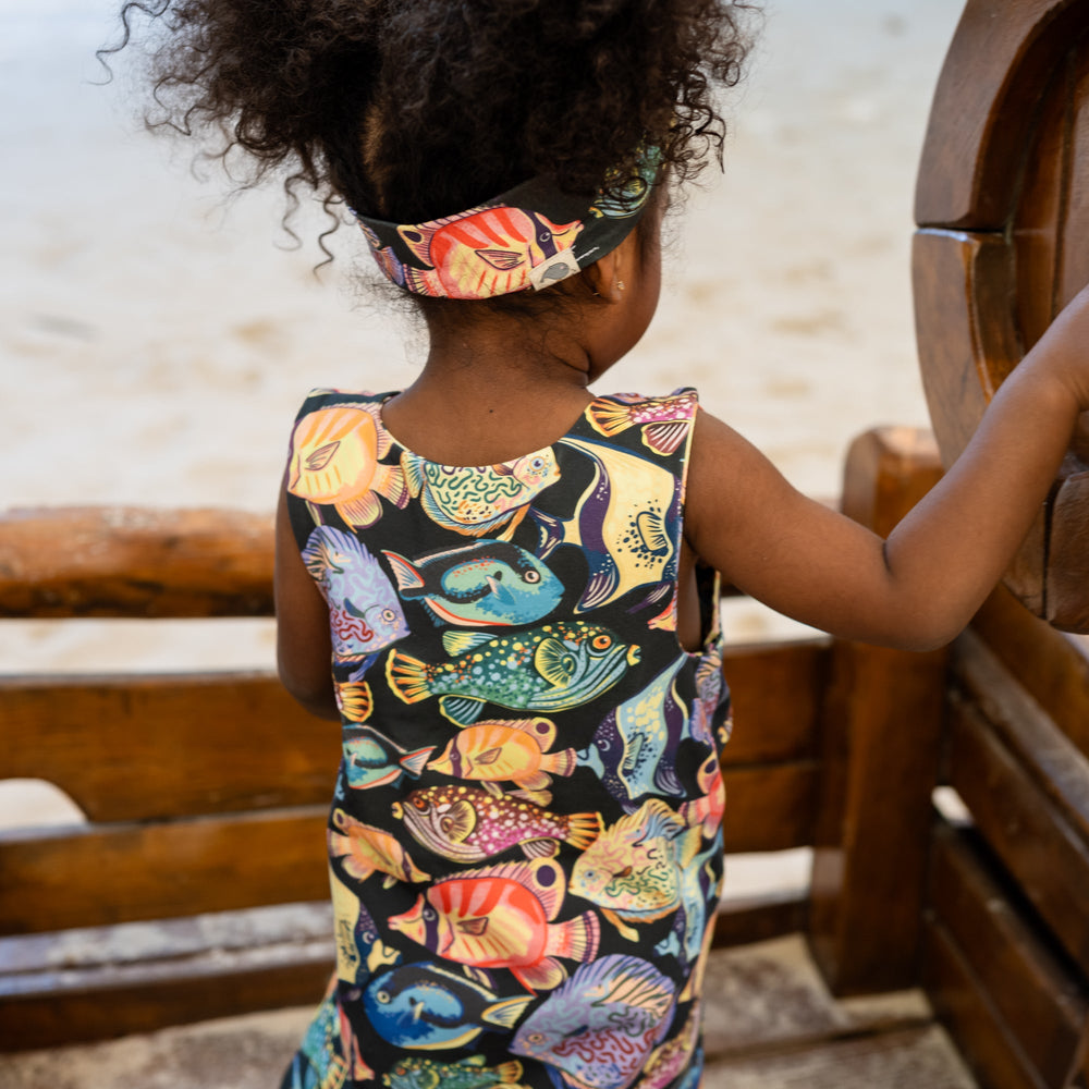 Child wearing colorful fishes on a handmade onsie