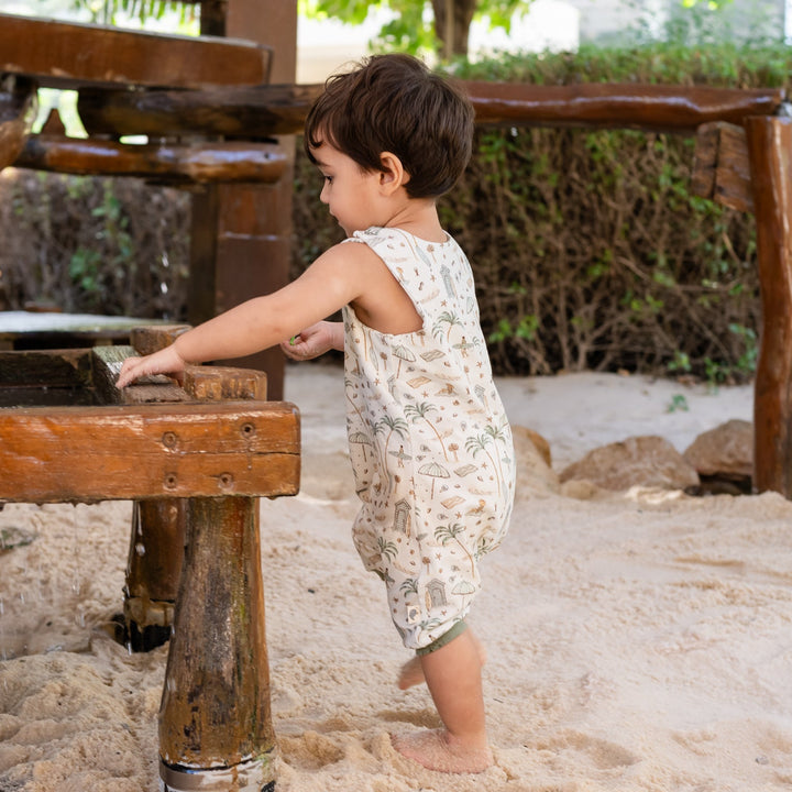 Child playing with water at a wooden fountain in a garden setting