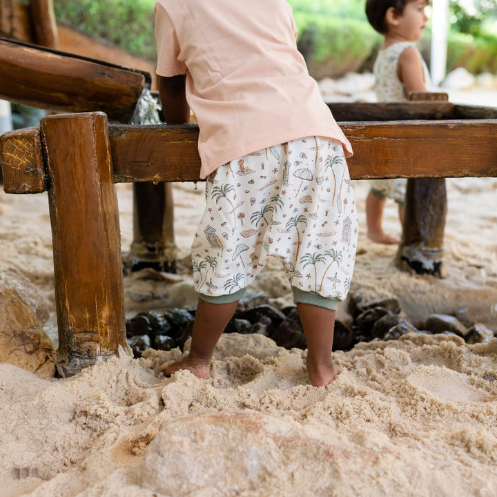 Children playing in a sand pit with wooden equipment